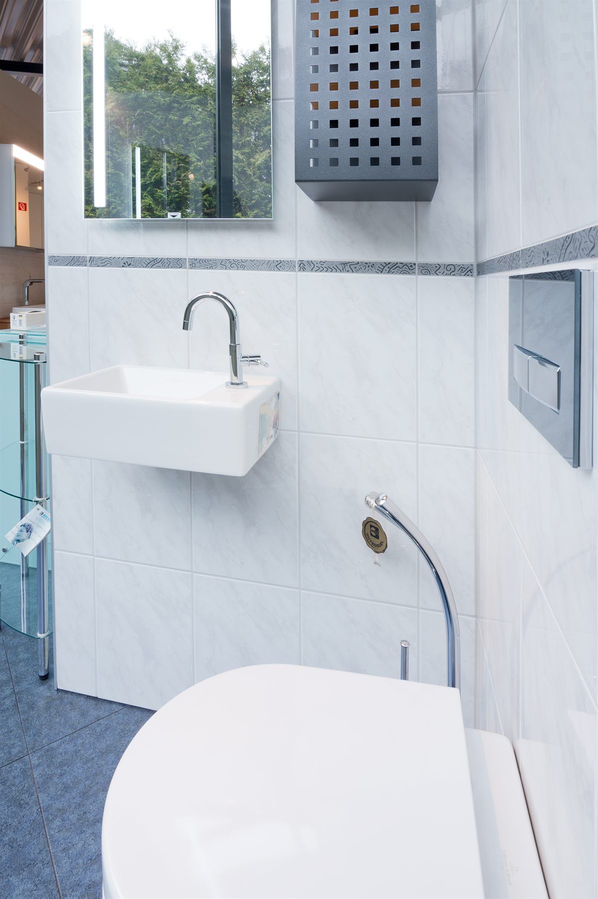 Wandhängender Waschtisch mit Unterputzarmatur neben freistehender Badewanne und Regendusche